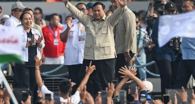 Presiden Prabowo Subianto menyapa massa buruh dari mobil kepresidenan saat menuju lokasi peringatan Hari Buruh Internasional atau May Day 2026 di kawasan Monumen Nasional (Monas), Jakarta, Jumat (1/5/2026).