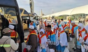 Jamaah haji asal Indonesia berbaris naik ke bus di area Bandar Udara Internasional Pangeran Mohammad bin Abdul Aziz