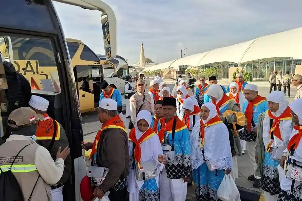 Jamaah haji asal Indonesia berbaris naik ke bus di area Bandar Udara Internasional Pangeran Mohammad bin Abdul Aziz