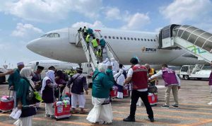 Calon jamaah haji mengantre menaiki pesawat.