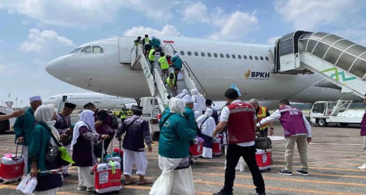 Calon jamaah haji mengantre menaiki pesawat.