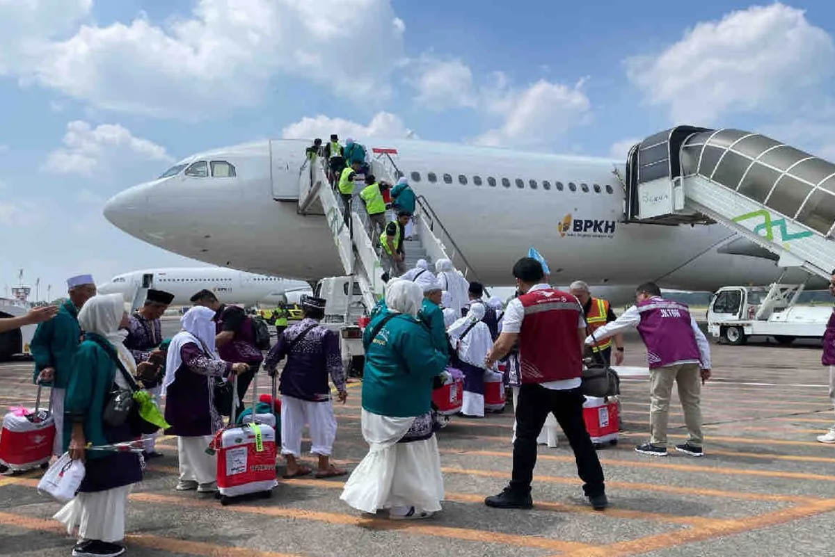 Calon jamaah haji mengantre menaiki pesawat.